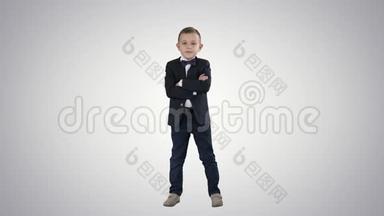 小男孩穿着<strong>渐变背景</strong>的正式服装交叉双手。